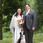 couple in wedding attire with their dog